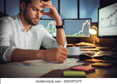 Serious businessman thinking hard of problem solution working late in office with computers documents, thoughtful trader focused on stock trading data analysis, analyzing forecasting financial rates - Shutterstock ID 1069297679