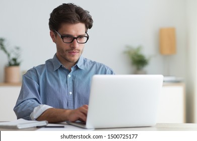 Serious Businessman Working At Laptop Computer Typing Something In Office. Business Career Concept. Copy Space