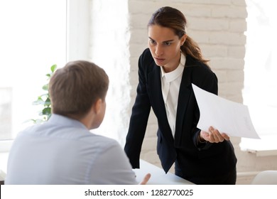 Serious businesswoman blaming employee for mistake in paper document, financial report, dissatisfied woman, ceo, team leader arguing with worker about bad work results, failure, business problem - Powered by Shutterstock