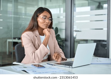 Serious busy young African American business woman manager executive looking at laptop computer thinking of financial digital market risks, considering new corporate strategy idea, watching webinar. - Powered by Shutterstock