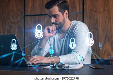 A serious caucasian programmer in casual wears, using laptop to develop a new security system to protect data. Double exposure. IT lock hologram icon. - Powered by Shutterstock - Get 15% off with code: PIKWIZARD15