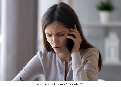 Serious concerned woman talking on phone helping solving problem customer complaint, stressed worried girl discussing business issue speaking by cell mobile making call having difficult conversation - Shutterstock ID 1297544728