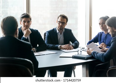 Serious Confident Businesspeople Listening To Mentor Leader At Meeting In Boardroom, Sitting At Table At Briefing, Business Partners Colleagues Discussing Project Strategy, Contract Terms