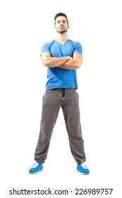 Serious confident fit guy posing with crossed hands and head back. Full body length isolated over white background.