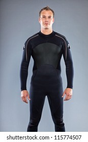 Serious Confident Man With Short Hair Wearing Wetsuit. Kite Surfer. Studio Shot. Isolated On Grey Background.