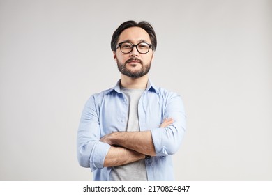 Serious confident young Asian web designer with black beard standing against isolated background and looking at camera - Shutterstock ID 2170824847