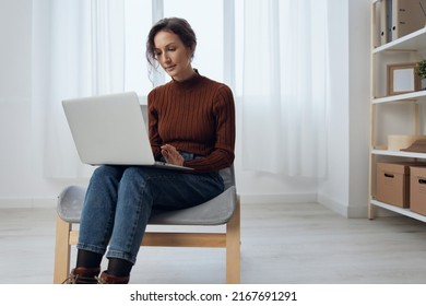 Serious Confused Unhappy Beautiful Curly Young Lady Work From Home Using Laptop Get Shocked Information Online In Social Media Sitting In Chair At Home. I Can Not Believe It Concept. Copy Space