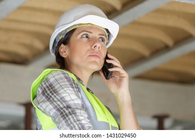 Serious Construction Worker On The Phone Indoors