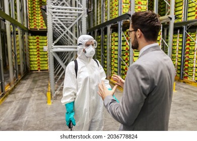 Serious Coronavirus Situation. Suppression Of COVID19 In The Manufacturer's Warehouse. The Manager Talks To The Person In Charge Of Disinfecting The Space About The Work Plan COVID-19 Measure Pandemic