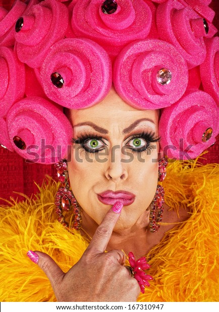 Serious cross
dressing man with finger on
lips