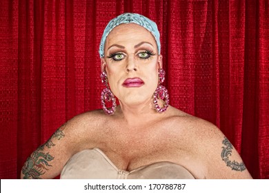 Serious Cross Dressing Man With Tattoo And Curtain