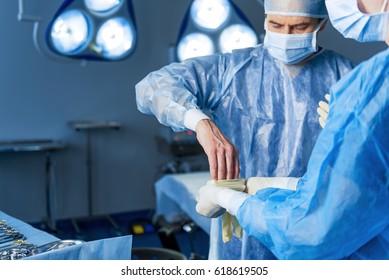 Serious doctor dressing protective clothes