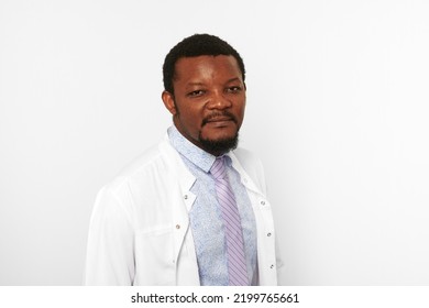 Serious Doctor Man With Small Beard In White Coat Bright Shirt Isolated On White Background. Adult Black African American Physician Therapist Portrait, Attractive Practitioner Family Doctor