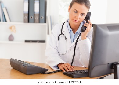 Serious Doctor On The Phone In Her Office