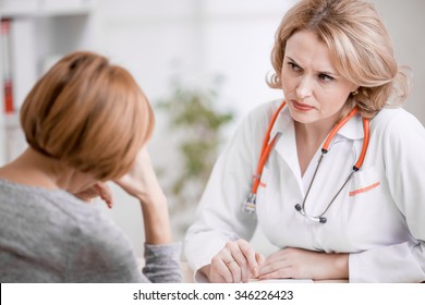 Serious Doctor Or Physician Looking At Upset Patient