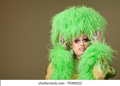 Serious Drag Queen Holds Wig On Green Background