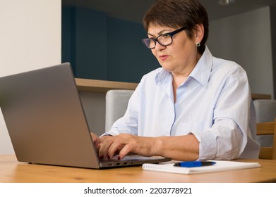 Serious Elder Woman Woking On Laptop At Home. Business Woman. Remote Work Concept