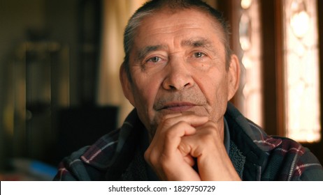 Serious elderly man thinking, looking at camera, closeup portrait. Shallow DOF.