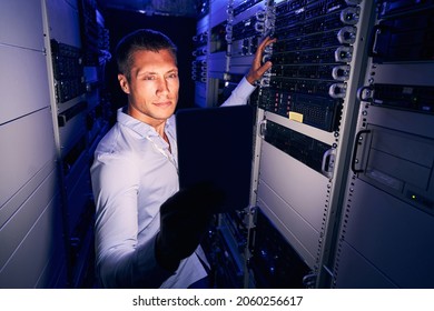 Serious Engineer Checking IT Equipment In Server Room