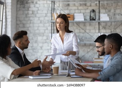 Serious Executive Businesswoman Manager Gives Handout In Boardroom At Meeting. Young Female Teacher Coach Lead New Project Presentation For Colleagues, Conversation At Negotiation, Discussing Results