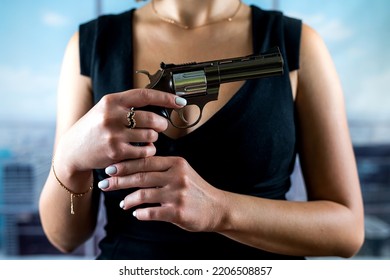 Serious Faceless Woman In A Stylish Dress Holds A Revolver For A Shot Against The Background Of Office Windows. Woman Killer Shooting. Office Robbery