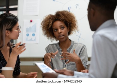 Serious female african leader manager talking during group office briefing teaching multiracial corporate business team explain coworkers clients project plan discuss company strategy at meeting