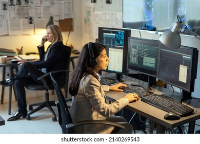 Serious female agent of intelligence service sitting in front of computer monitors in office and processing personal data of criminals - Shutterstock ID 2140269543