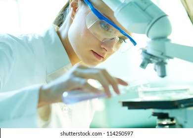 Serious Female Chemist Working In Laboratory