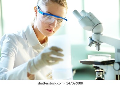 Serious Female Chemist Working In Laboratory