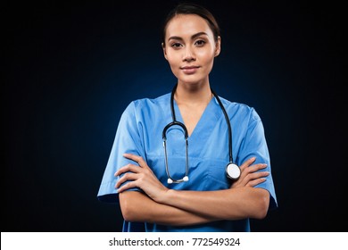 Serious Female Doctor Looking Camera With Folded Hands And Stethoscope Isolated Over Black