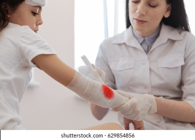 Serious female doctor stopping bleeding