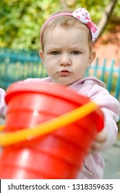 A Serious, Frowny Little Girl Not Giving Her Toys On A Playground. Ability To Share Your Own Toys With Other Children. Behavior Of The Child In The Kindergarten. Communication Problems. Ownership.