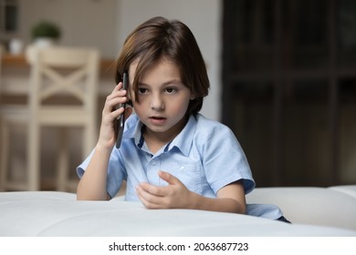 Serious Gen Z Kid Making Telephone Call, Talking On Mobile Phone Alone At Home. School Boy Speaking To Parent On Smartphone, Listening. Connection, Communication, Childhood Concept