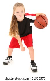 Serious Girl Child Basketball Player In Uniform Dribbling Ball Between Legs Over White Background.