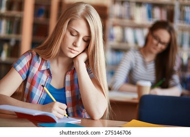 Serious Girl Making Notes At Lesson In College