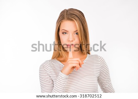 Serious girl in shirt holding finger on lips