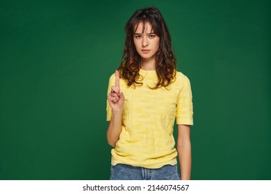 Serious girl showing admonishing finger gesture, saying no, be careful, raised up forefinger. Authority and morality - Shutterstock ID 2146074567
