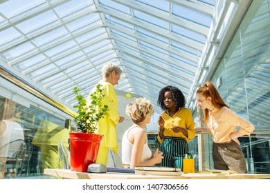 serious girls in bright colorful casual wear discussing a topic. fashion designers brainstorming in the office room - Powered by Shutterstock