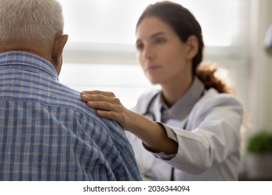 Serious GP doctor giving support to elderly 80s patient after telling bad news, holding, touching shoulder. Older man getting bad diagnosis, hard mental disease, late cancer. Elderly medic care - Powered by Shutterstock