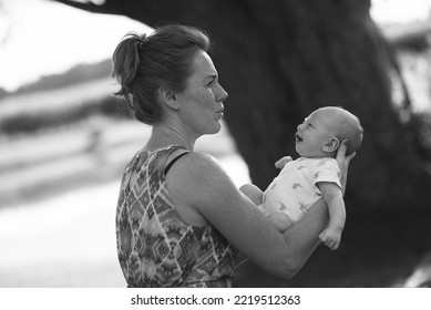 Serious Grandmother Is Holding On Hands Her Grandson Baby And Playing With Him