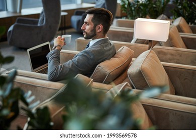 Serious handsome person drinking coffee in the business lounge - Shutterstock ID 1993569578