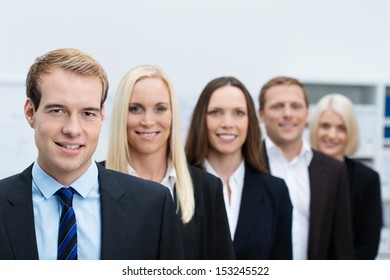 Serious Handsome Young Business Manager With His Successful Team Of Diverse Business People Lined Up Behind Him