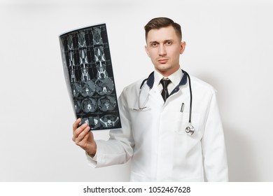 Serious handsome young doctor man holds x-ray radiographic image ct scan mri isolated on white background. Male doctor in medical uniform, stethoscope. Healthcare personnel, health, medicine concept - Shutterstock ID 1052467628