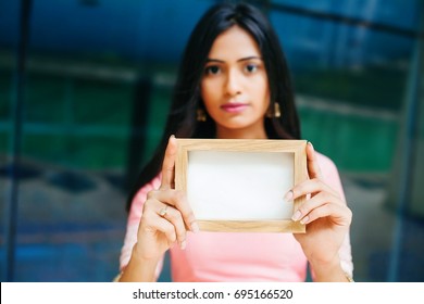 Serious Indian Woman Holding An Empty Frame