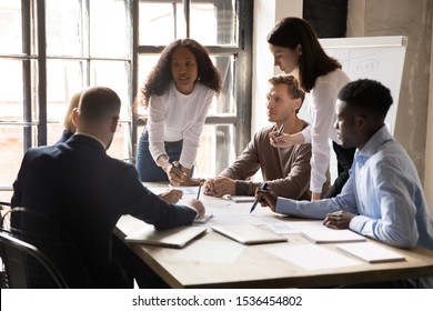 Serious international diverse business team people   african female leader boss discuss financial result review paperwork share ideas brainstorm collaborate work in teamwork at group briefing table
