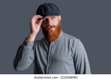 Serious Irish Guy Adjusting Cap. Portrait Of Bearded Guy. Unshaven Guy With Beard Studio