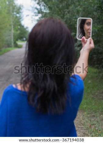 serious lady looking at the mirror