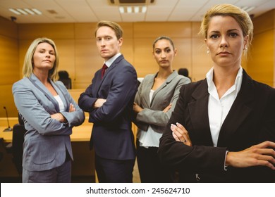 Serious Lawyer Standing With Arms Crossed In The Court Room