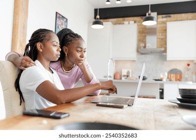 Serious lesbian couple using laptop at home - Powered by Shutterstock