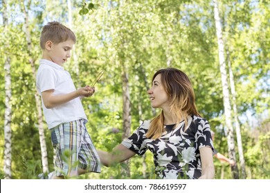  Serious little boy talking with his mother in the city park on a summer sunny day